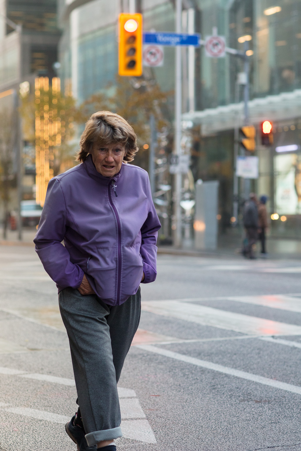 Homeless woman walks in the middle of the road at the Bloor/Yonge Intersection, Toronto.