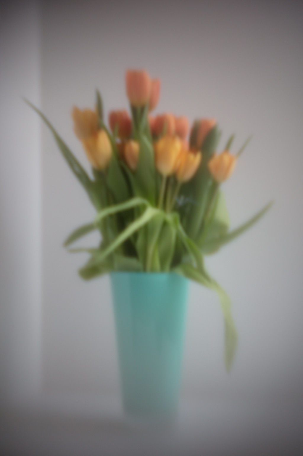 Still life of orange tulips in a turquoise vase