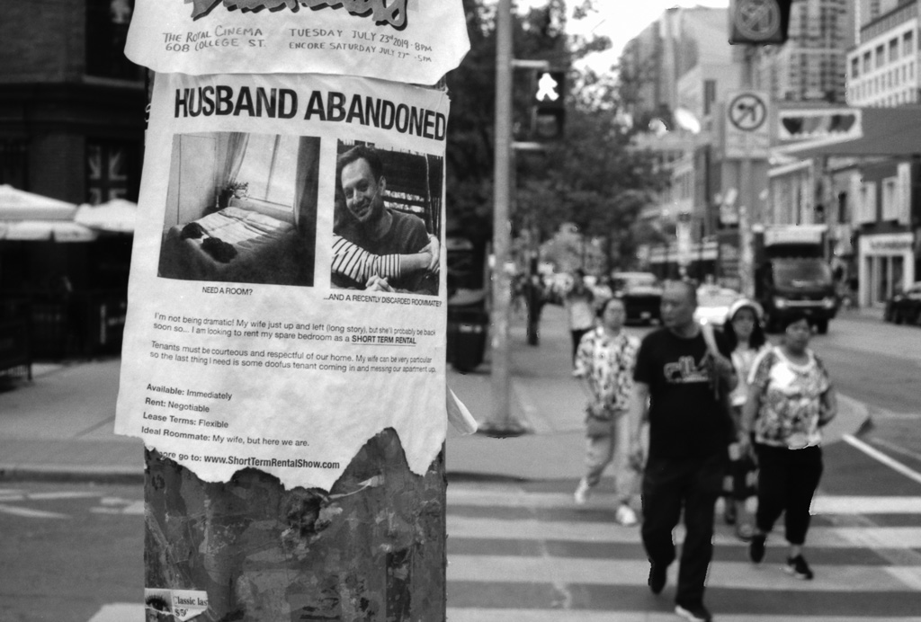 Poster on utility pole: rental ad titled Husband Abandoned