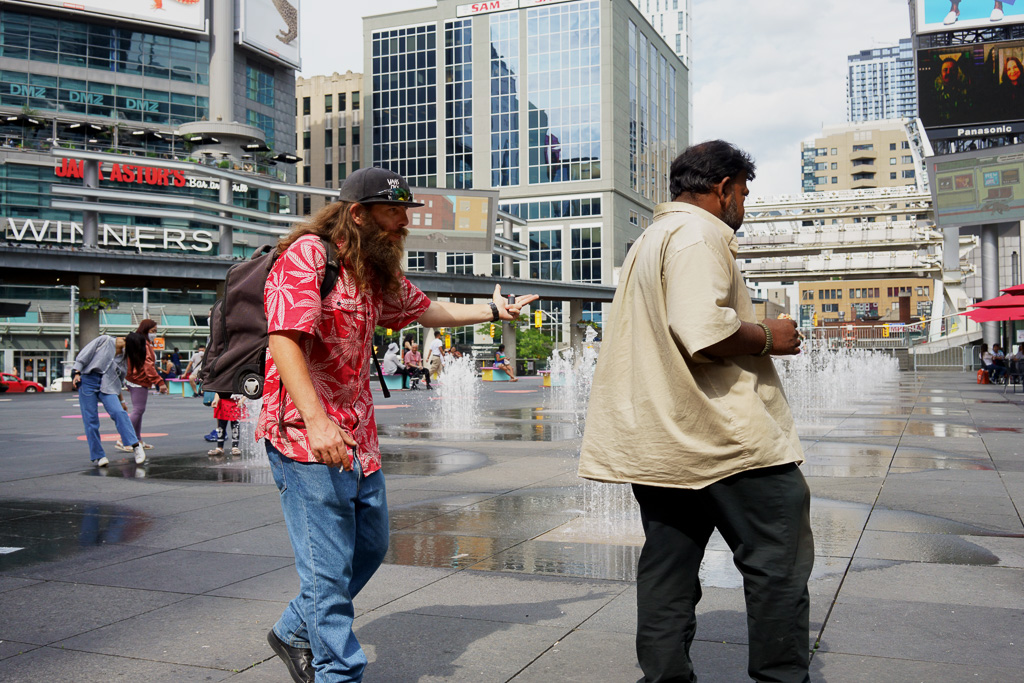 One man accosts another man in Toronto's Dundas Square