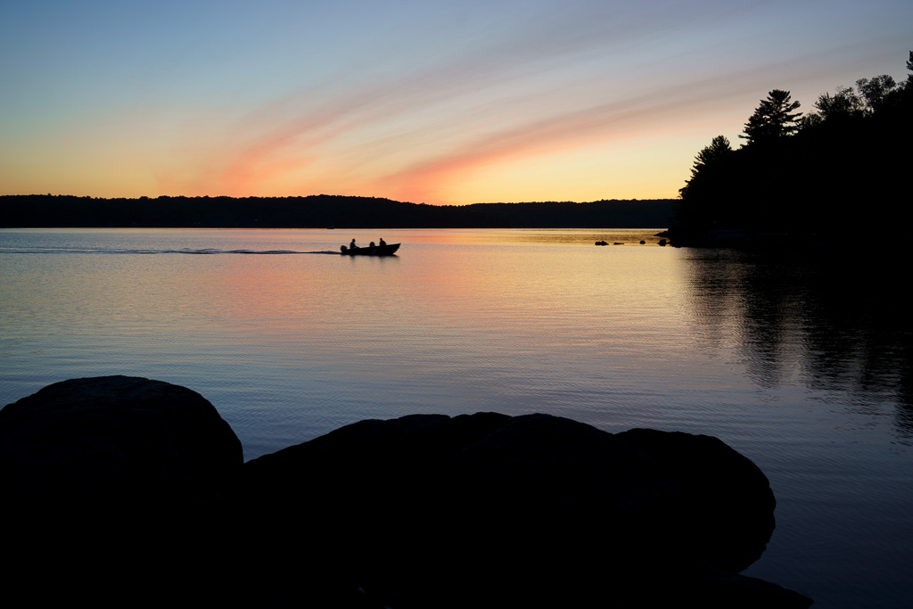 People in a boat at sunset on Bob Lake, Haliburton Highlands, Ontario