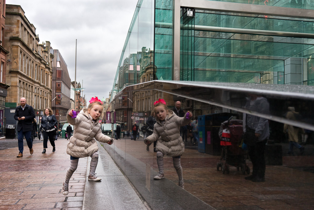 Child climbs a step on Buchanan Street, Glasgow, Scotland