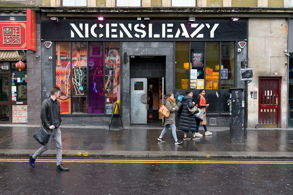 A man watches 3 women walk past Nice N Sleazy, a bar on Sauchiehall Street in Glasgow