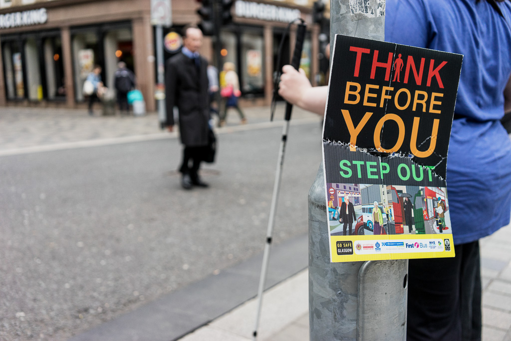 Sign on pole: "Think Before You Step Out."