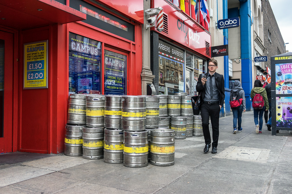 Man walks past beer kegs at Sauchiehall & Scott Street, Glasgow