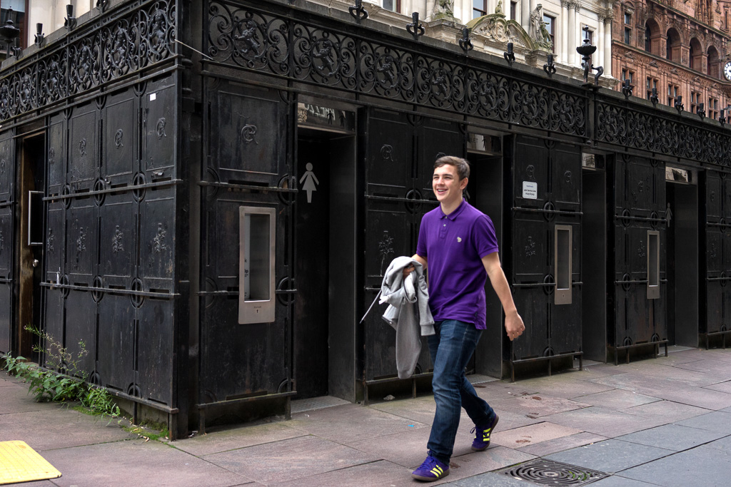 Youth walking past public lavatories at Buchanan Street & St. Vincent Place in Glasgow
