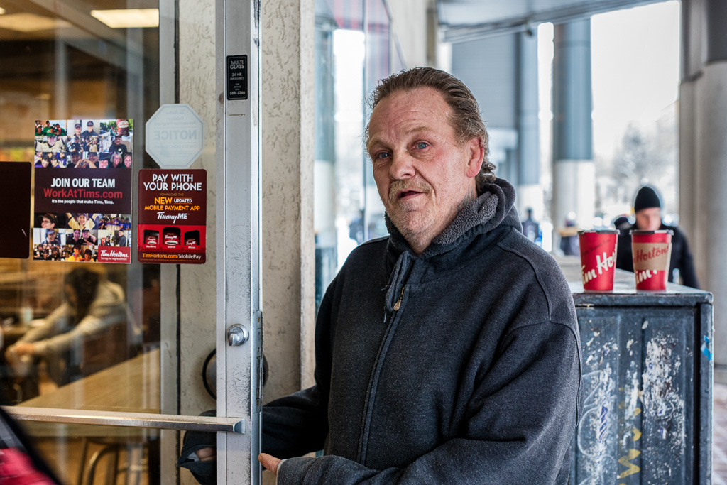 Scott holds open the door at the Tim Horton's on Victoria Street, Toronto