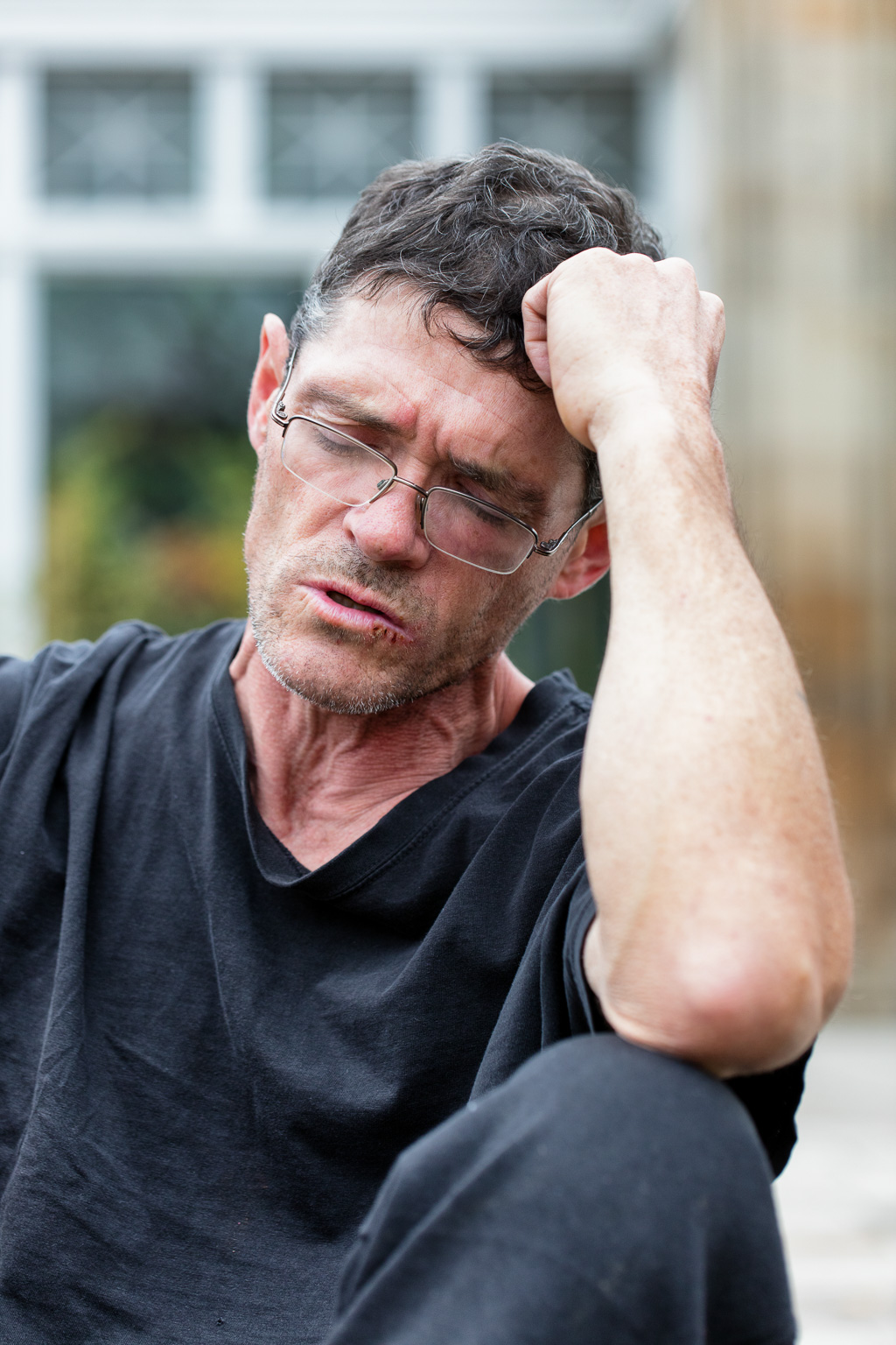 Homeless man rest with elbow on knee