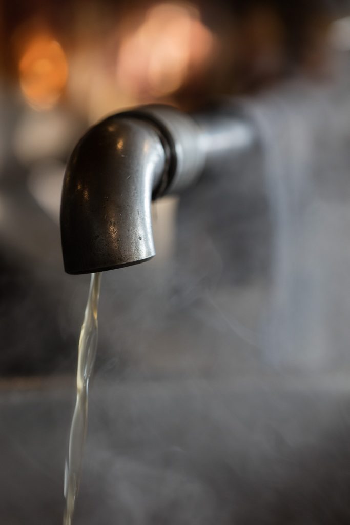 Maple Syrup pours from a faucet after going through the evaporator.