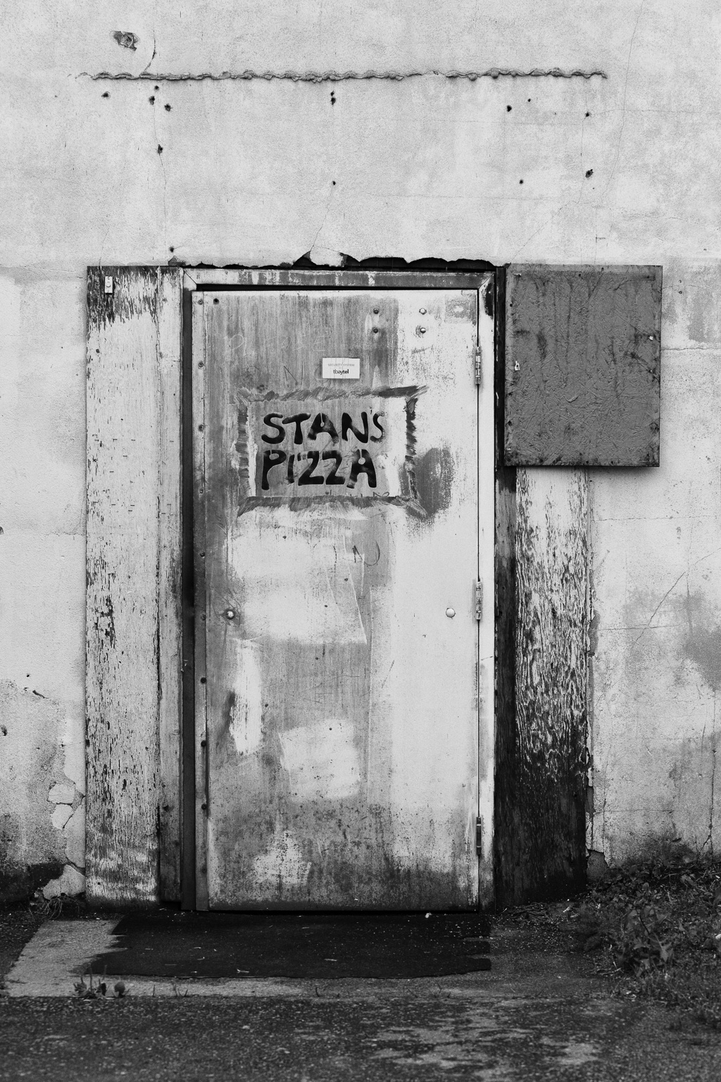 Gritty door with a sign on it that says: Stan's Pizza