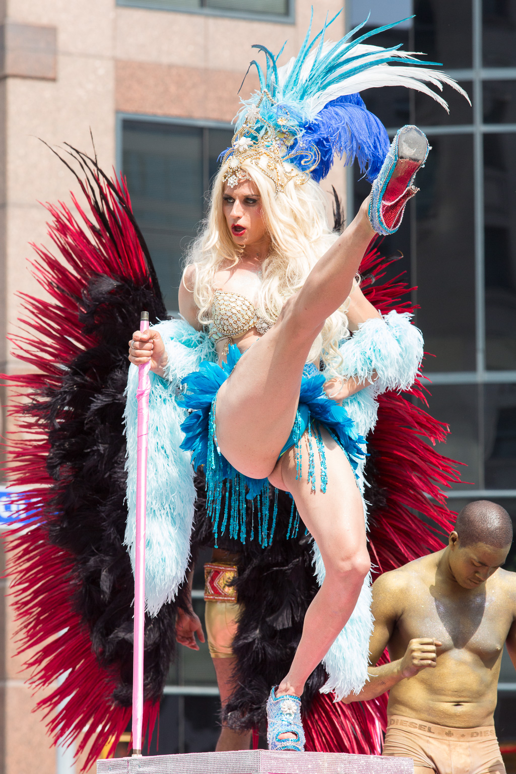 A person dressed in drag does a high kick.