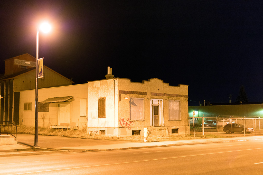 Night shot of a low building illuminated by a single street light.